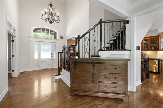 8701 W 157th St, Overland Park, KS 66221 - foyer featuring stairway, dark wood finished floors, a chandelier, crown molding, and baseboards