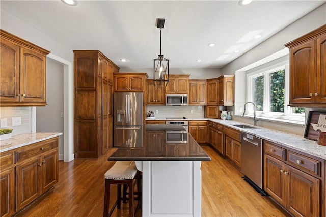 8701 W 157th St, Overland Park, KS 66221 - kitchen with stainless steel appliances, a sink, backsplash, light wood finished floors, and recessed lighting