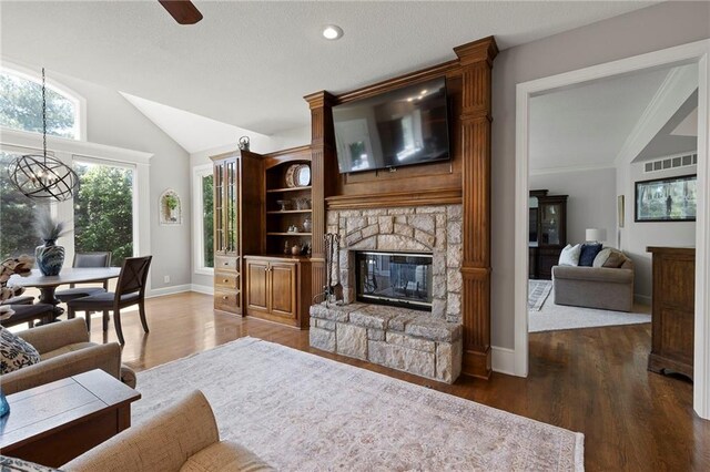 8701 W 157th St, Overland Park, KS 66221 - living area with lofted ceiling, a chandelier, wood finished floors, a fireplace, and baseboards