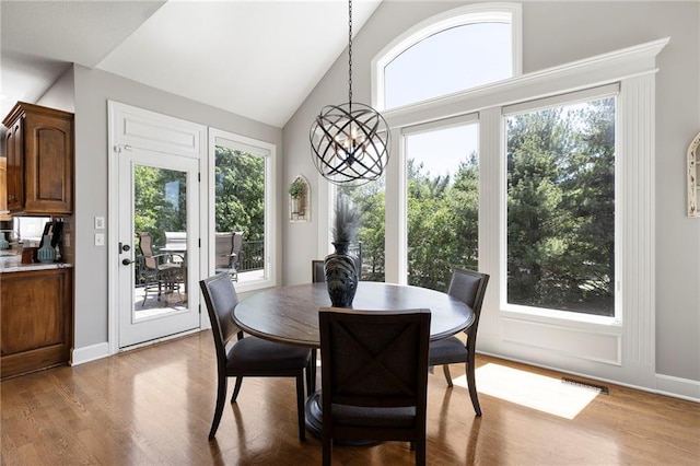 8701 W 157th St, Overland Park, KS 66221 - dining room featuring a chandelier, light wood-style flooring, baseboards, and high vaulted ceiling