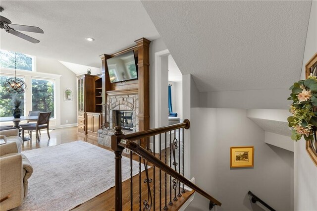8701 W 157th St, Overland Park, KS 66221 - living room featuring a textured ceiling, a ceiling fan, lofted ceiling, baseboards, and a chandelier
