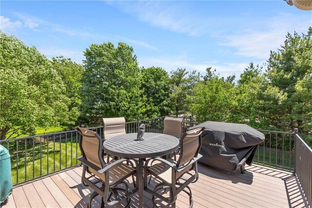 8701 W 157th St, Overland Park, KS 66221 - wooden deck featuring outdoor dining space and view of wooded area