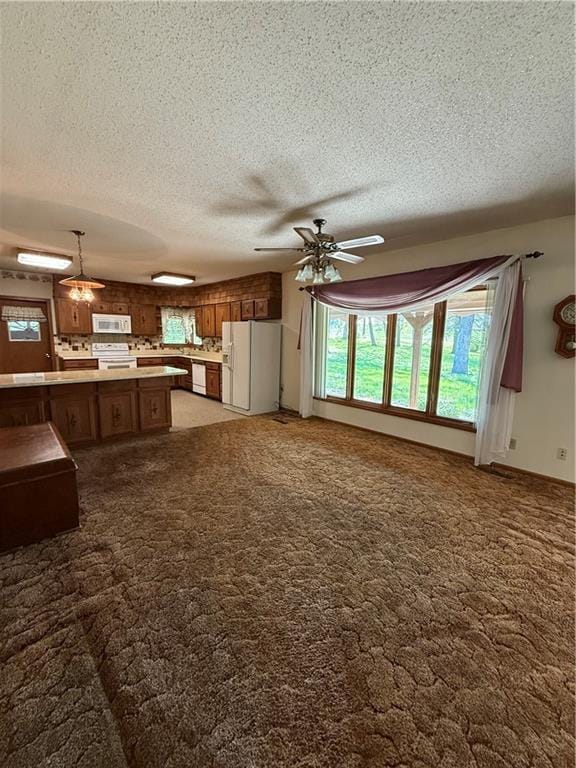unfurnished living room with light colored carpet, ceiling fan, and a textured ceiling