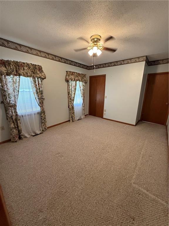 unfurnished bedroom with baseboards and multiple windows