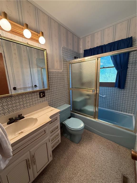 full bathroom with wallpapered walls, enclosed tub / shower combo, toilet, visible vents, and vanity