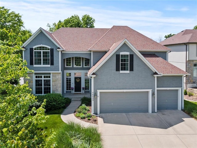 14692 S Garnett St, Olathe, KS 66062 - traditional-style home featuring stucco siding, driveway, roof with shingles, and stone siding