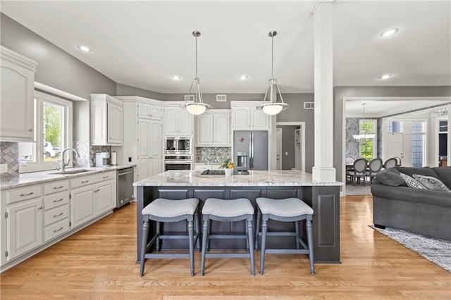 14692 S Garnett St, Olathe, KS 66062 - kitchen with stainless steel appliances, decorative backsplash, a kitchen breakfast bar, healthy amount of natural light, and recessed lighting