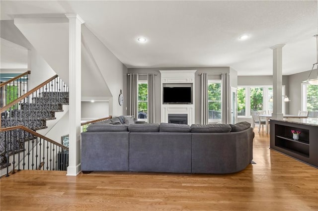 14692 S Garnett St, Olathe, KS 66062 - living room featuring light wood-type flooring, decorative columns, stairway, a fireplace, and recessed lighting