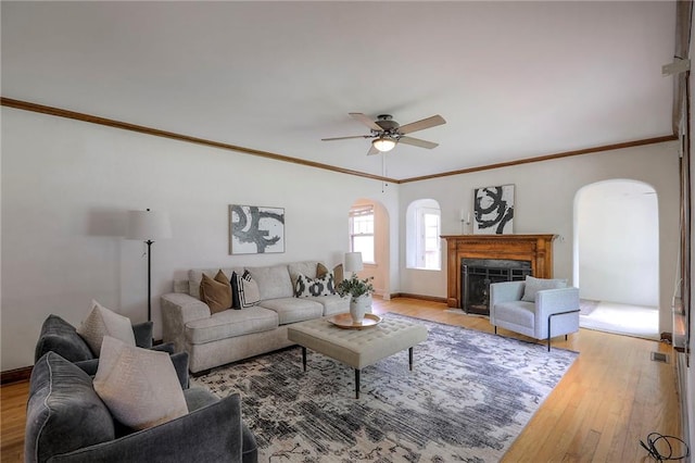 722 E Meyer Blvd, Kansas City, MO 64131 - living area with arched walkways, light wood-type flooring, ceiling fan, and ornamental molding