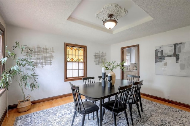 722 E Meyer Blvd, Kansas City, MO 64131 - dining area with light wood-style flooring, a tray ceiling, and a textured ceiling