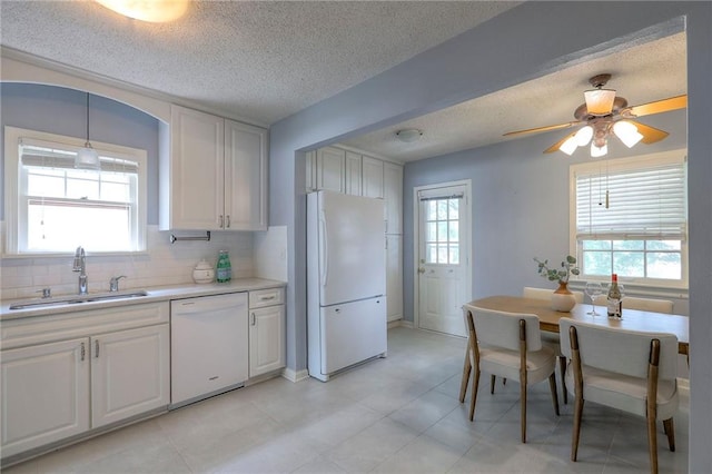 722 E Meyer Blvd, Kansas City, MO 64131 - kitchen featuring white appliances, light countertops, a textured ceiling, decorative backsplash, and white cabinetry