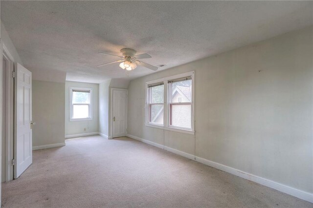 722 E Meyer Blvd, Kansas City, MO 64131 - unfurnished bedroom with a textured ceiling, light colored carpet, and a ceiling fan