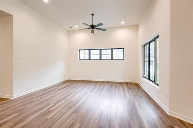 spare room featuring a ceiling fan, baseboards, recessed lighting, and wood finished floors