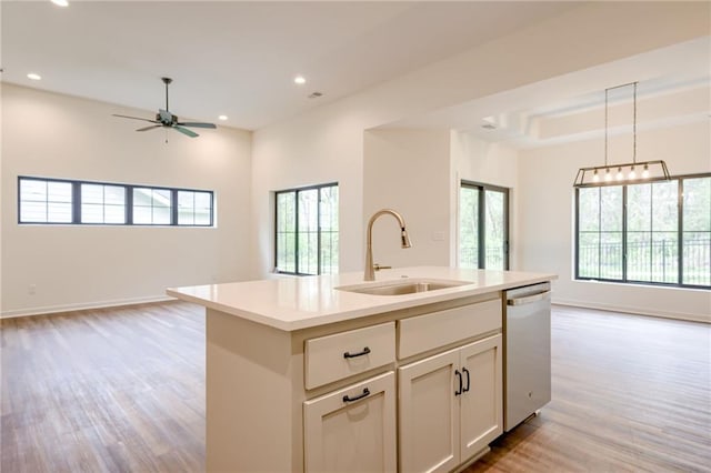 kitchen featuring dishwasher, light wood-style floors, open floor plan, and a sink