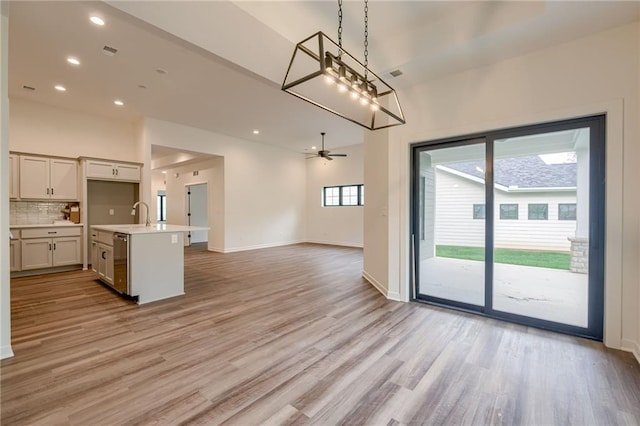 interior space featuring ceiling fan, light wood-style flooring, baseboards, and recessed lighting