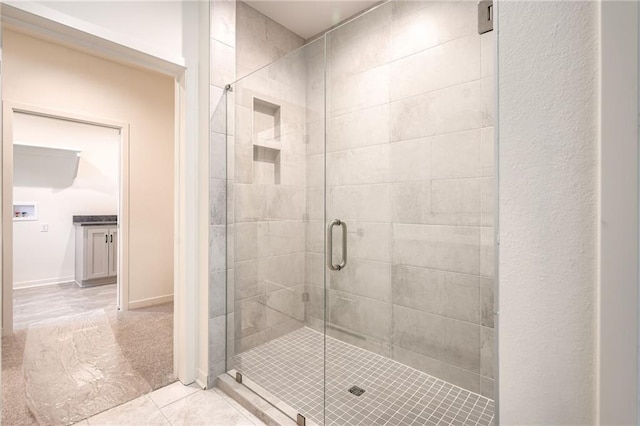 full bathroom featuring tile patterned floors and a shower stall