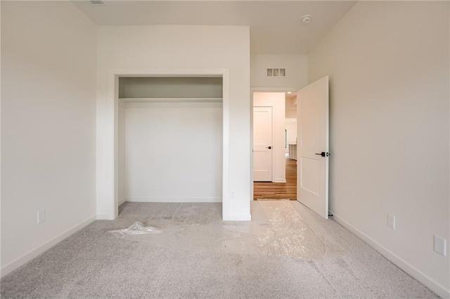unfurnished bedroom featuring carpet flooring, baseboards, a closet, and visible vents