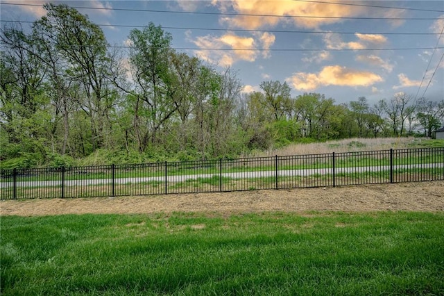 view of home's community with a yard and fence