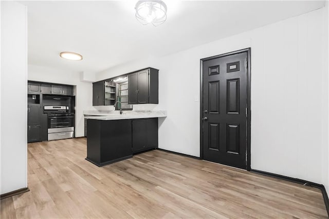 1910 Ottawa St, Leavenworth, KS 66048 - kitchen with stainless steel gas range, open shelves, a peninsula, light countertops, and a sink