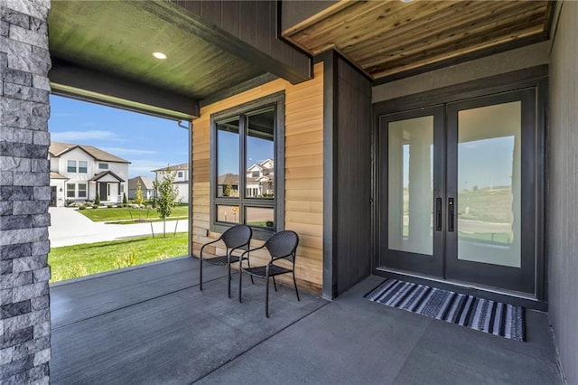 view of patio / terrace featuring a porch, french doors, and a residential view