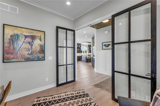 unfurnished office with french doors, wood finished floors, ornamental molding, visible vents, and recessed lighting