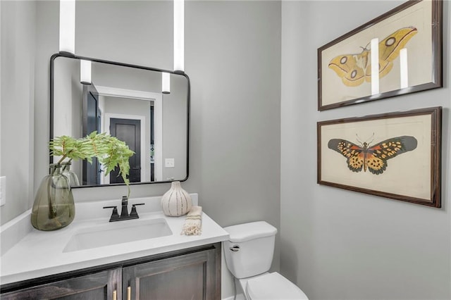 half bath featuring vanity and toilet