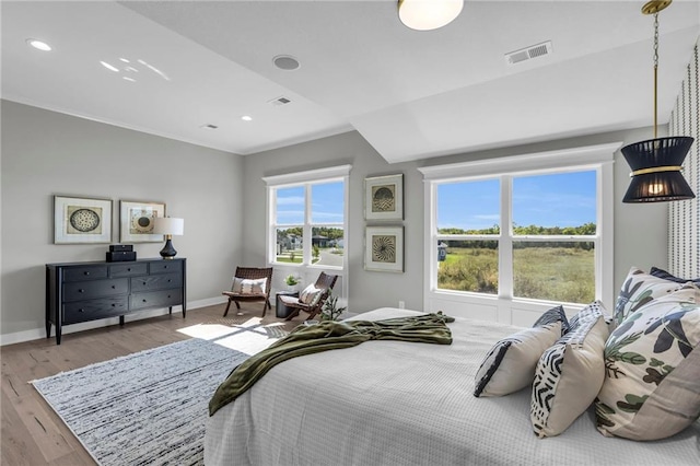 bedroom with baseboards, visible vents, and wood finished floors