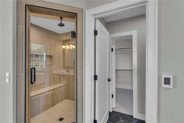 bathroom featuring a shower stall, a sauna, tile patterned floors, and a walk in closet