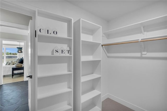 walk in closet with dark tile patterned floors
