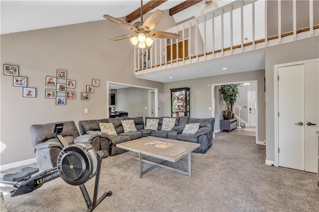 carpeted living area featuring baseboards, a ceiling fan, and high vaulted ceiling
