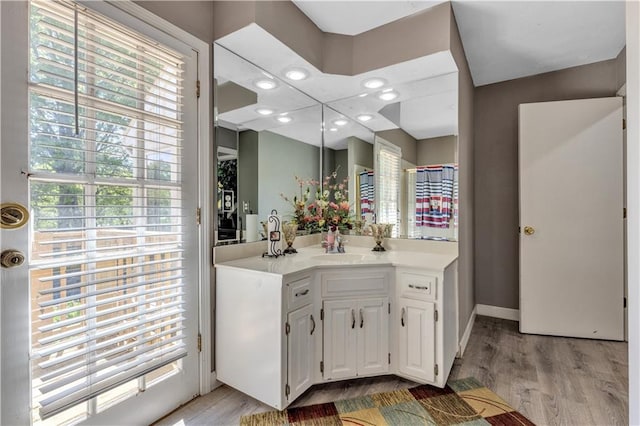 bathroom with baseboards, wood finished floors, and vanity