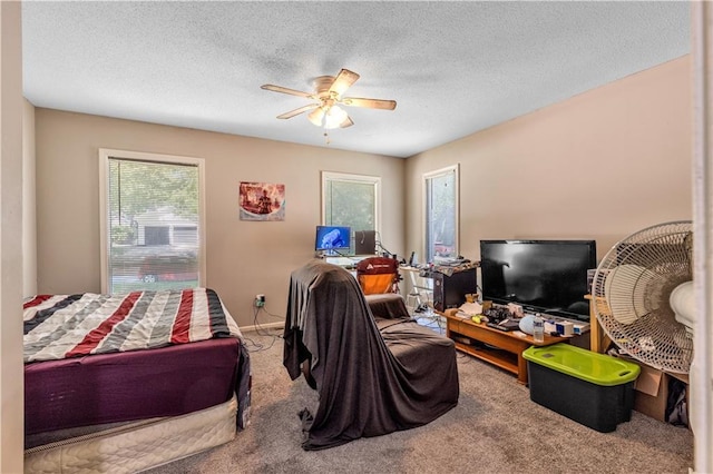 bedroom with carpet, a textured ceiling, and a ceiling fan