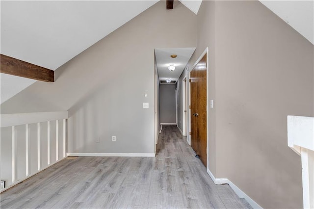 bonus room featuring lofted ceiling with beams, baseboards, and light wood-style floors