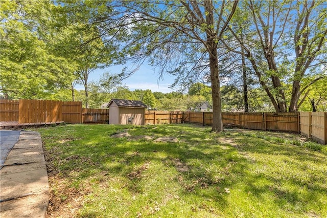 view of yard with an outbuilding, a fenced backyard, and a storage unit