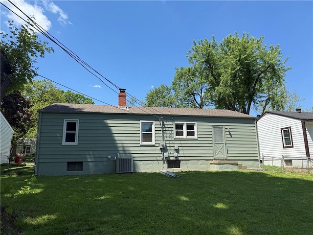 rear view of house with a chimney and central AC