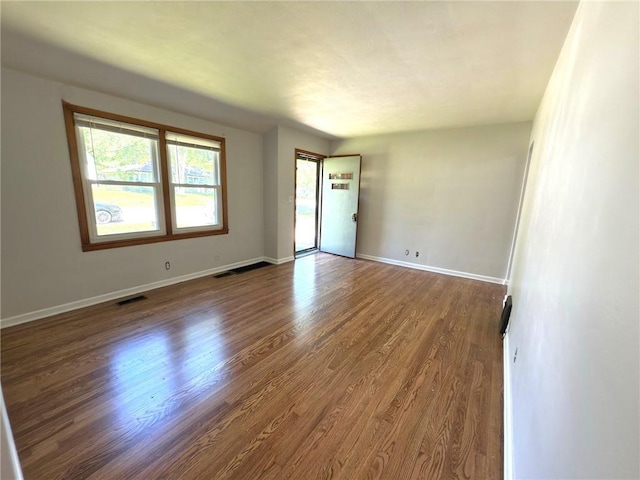 unfurnished room with wood finished floors and baseboards