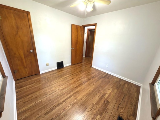 empty room featuring wood finished floors, ceiling fan, and baseboards