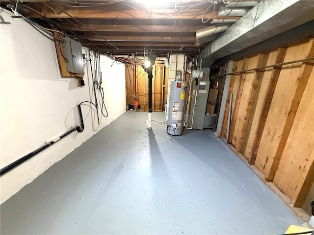 unfinished below grade area featuring gas water heater, electric panel, and heating unit