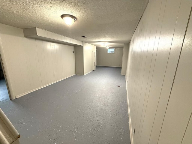 below grade area with a textured ceiling and baseboards
