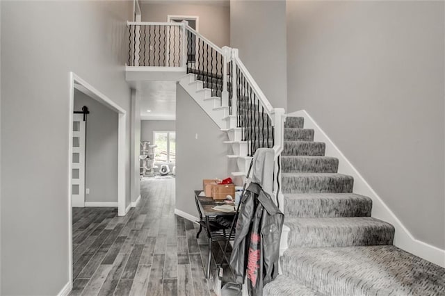 6700 N Charlston Dr, Kansas City, MO 64119 - staircase with wood finished floors, baseboards, and a high ceiling