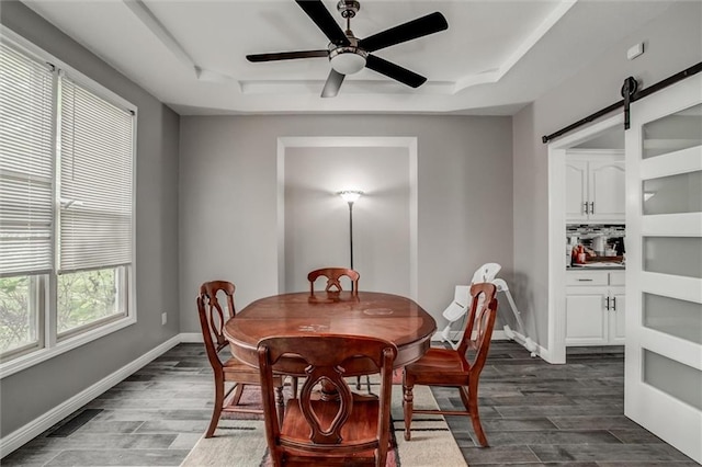 6700 N Charlston Dr, Kansas City, MO 64119 - dining room featuring dark wood-type flooring, baseboards, a tray ceiling, and ceiling fan