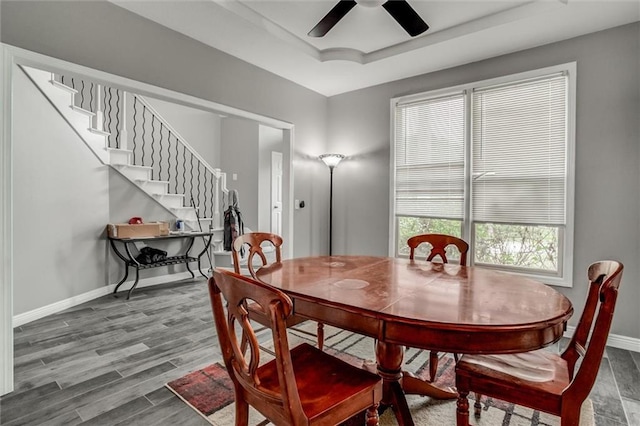 6700 N Charlston Dr, Kansas City, MO 64119 - dining space featuring a ceiling fan, baseboards, stairway, wood finished floors, and a tray ceiling