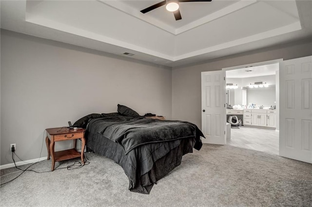 6700 N Charlston Dr, Kansas City, MO 64119 - bedroom with a tray ceiling, carpet floors, baseboards, and connected bathroom