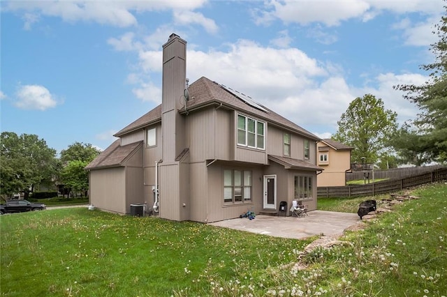 6700 N Charlston Dr, Kansas City, MO 64119 - back of property featuring a patio, roof with shingles, cooling unit, a chimney, and solar panels