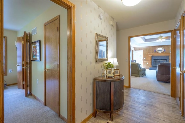corridor featuring baseboards and light wood-style floors