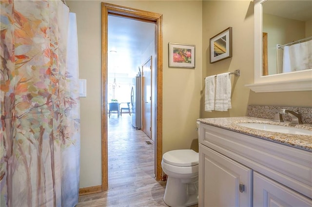 full bathroom featuring wood finished floors, toilet, and vanity