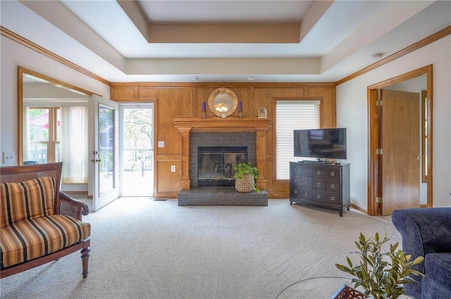 carpeted living room featuring a glass covered fireplace, healthy amount of natural light, and ornamental molding