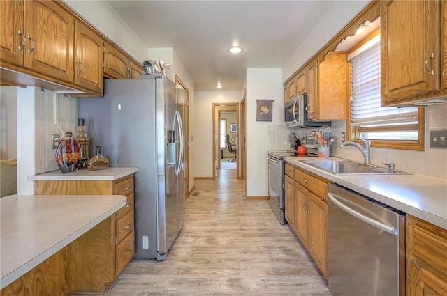 kitchen featuring stainless steel appliances, brown cabinetry, tasteful backsplash, light wood finished floors, and light countertops