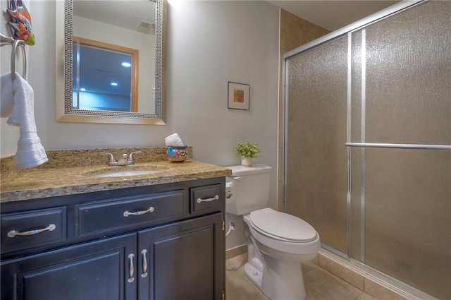 bathroom featuring tile patterned flooring, a stall shower, toilet, and vanity