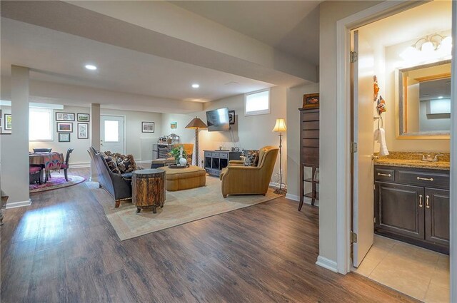 living room featuring light wood finished floors, plenty of natural light, baseboards, and recessed lighting